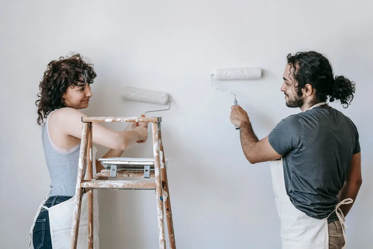 People painting a wall together — painting help in Manchester