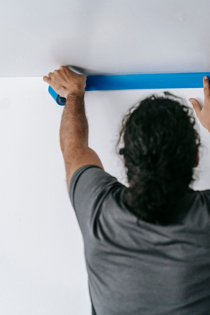 Painter applying tape before painting